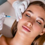 Young woman gets beauty facial injections in salon